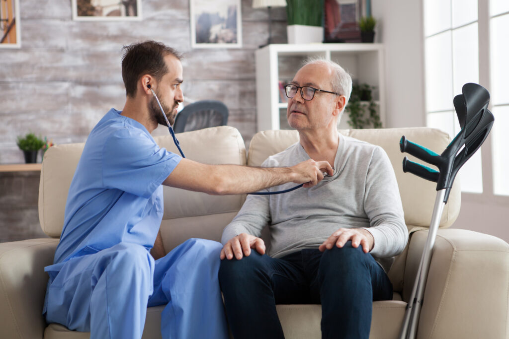 Young male nurse with stethoscope listening the heart