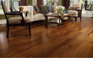 A stylish living room featuring rich, dark hardwood flooring with a comfortable seating area, showcasing elegant furniture and natural lighting.