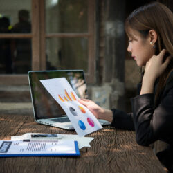 Business professional analyzing financial charts and reports on a laptop for outsourced financial reporting and CFO services.