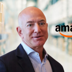 Bald business executive standing inside an Amazon warehouse, representing the growth of e-commerce and wealth behind Jeff Bezos Net Worth 2025